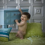 small boy by a blue table with silver tiles in the background
