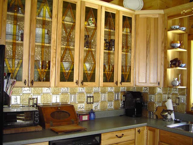 0512-gwens-cabin-clear-antique-brass-backsplash.jpg kitchen cabients with stained glass and 2 color backsplash