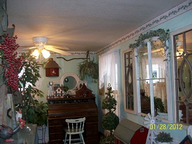 Before image of an Living Room with green walls, big window and a hardwood floor.