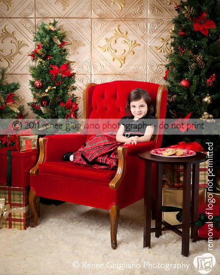 Christmas photography set with a red chair, two christmas trees and styrofoam ceiling tiles painted gold as a backdground.