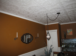 Dining Room with Brown Walls and Decorative Ceiling Dining room with brown walls, decorative ceiling tiles and wainscoting.