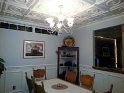Beautiful dining room with white ceiling tiles and wainscoting.