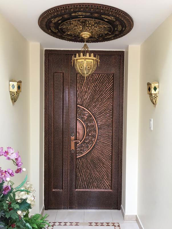 A bronze ceiling medallion hangs above a matching light fixture in an entry hallway