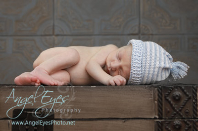Image of a newborn baby on a table by Angel Eyes Photography and our ceiling tiles as a backdrop.
